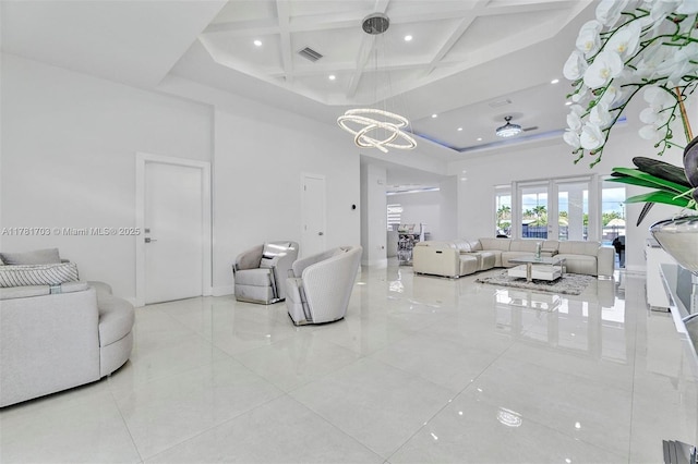 tiled living room with visible vents, an inviting chandelier, a high ceiling, beamed ceiling, and coffered ceiling