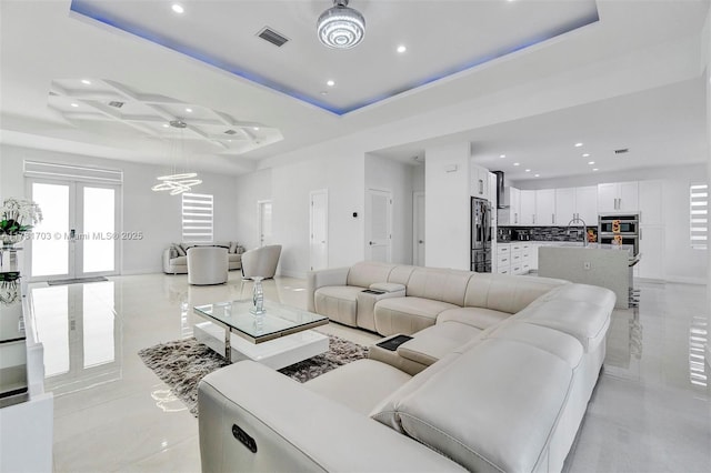 living area featuring an inviting chandelier, recessed lighting, french doors, visible vents, and coffered ceiling