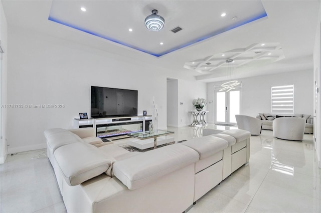 living area featuring baseboards, recessed lighting, light tile patterned floors, visible vents, and a raised ceiling