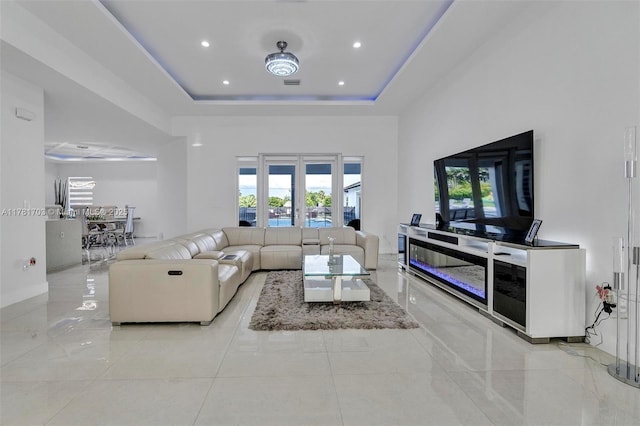living area with a healthy amount of sunlight, recessed lighting, and a raised ceiling
