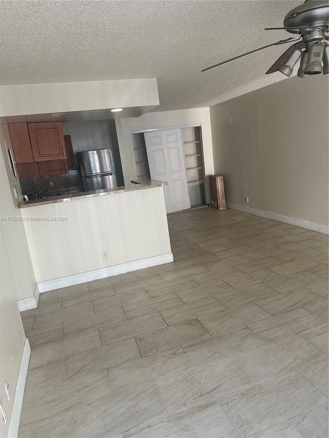 3161 Coral Ridge Dr, Coral Springs, FL 33065 - kitchen with brown cabinets, baseboards, a ceiling fan, and a textured ceiling