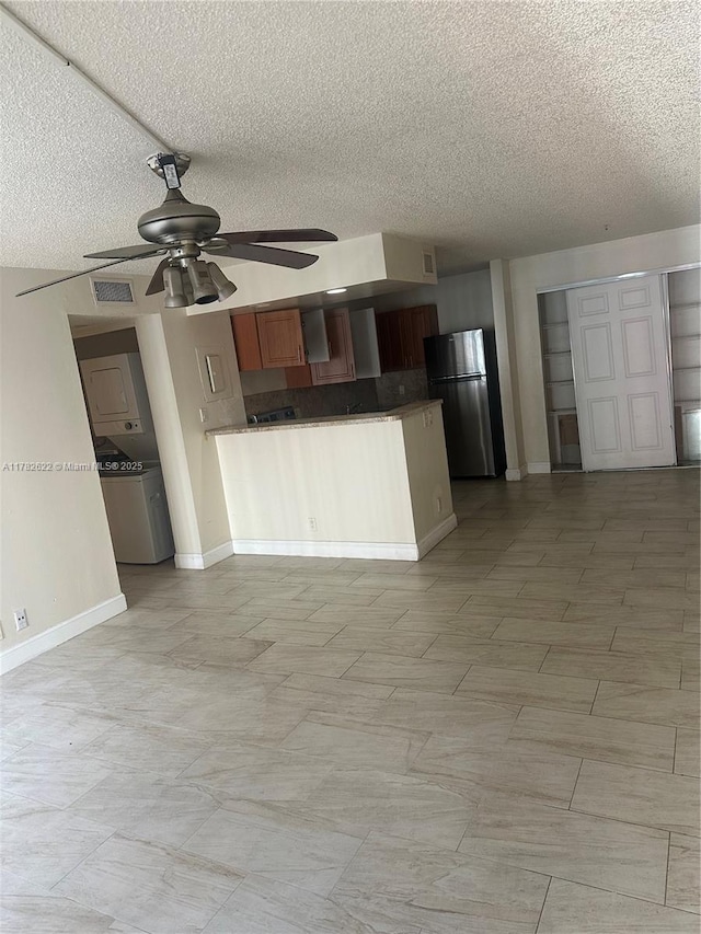 3161 Coral Ridge Dr, Coral Springs, FL 33065 - kitchen with a peninsula, a textured ceiling, freestanding refrigerator, and ceiling fan