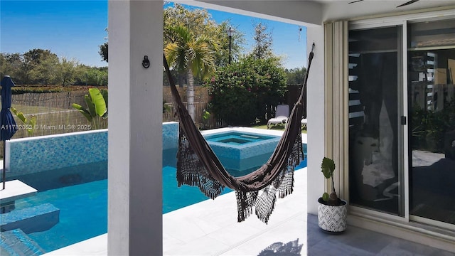 view of pool with a jacuzzi and a fenced backyard