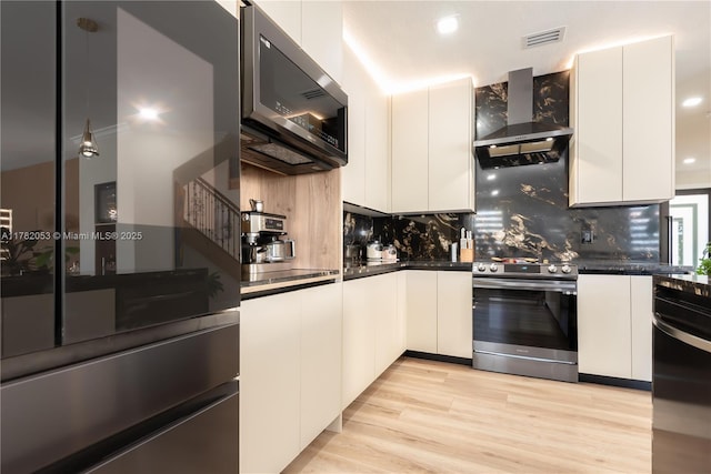 kitchen featuring wall chimney range hood, electric stove, fridge, and dark countertops