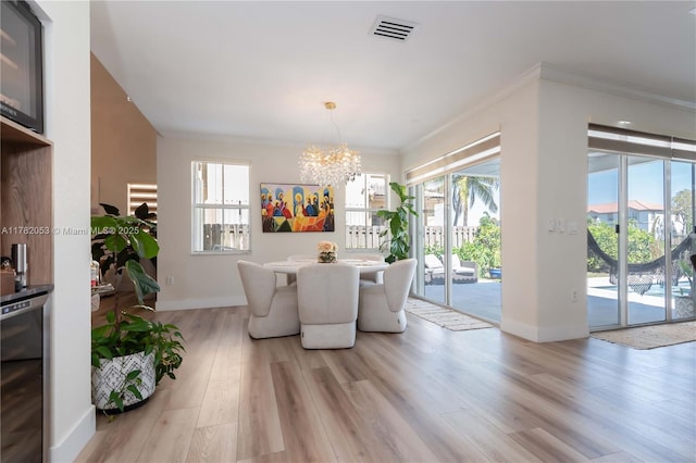 dining room featuring visible vents, baseboards, an inviting chandelier, light wood-style floors, and beverage cooler
