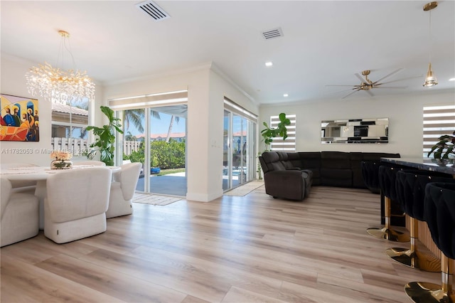 living room featuring crown molding, visible vents, and light wood-style floors