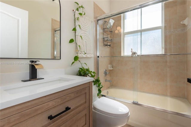 full bath featuring enclosed tub / shower combo, vanity, and toilet
