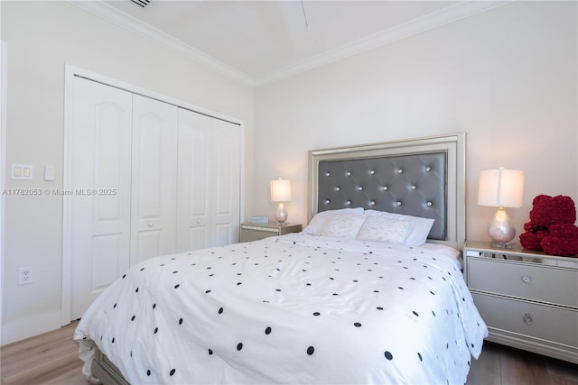 bedroom with a closet, ornamental molding, and wood finished floors