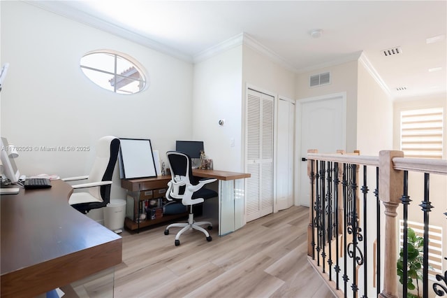 office area featuring light wood-style floors, ornamental molding, and visible vents