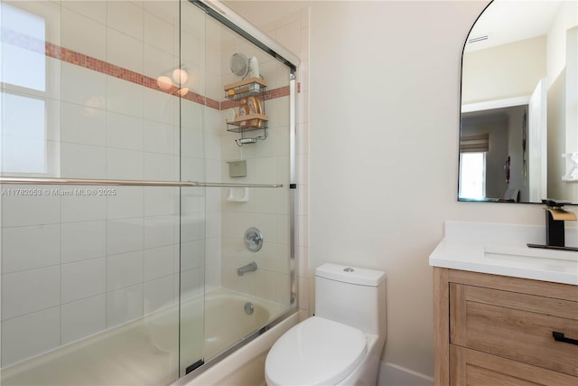 bathroom with toilet, shower / bath combination with glass door, and vanity