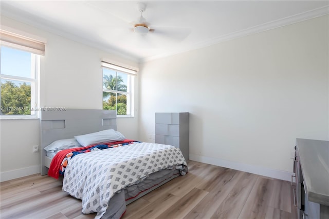 bedroom with ornamental molding, light wood-style flooring, and multiple windows