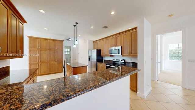 4713 Village Way, Davie, FL 33314 - kitchen with stainless steel appliances, dark stone counters, light tile patterned floors, recessed lighting, and brown cabinetry