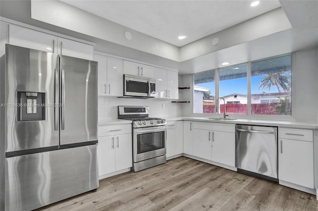 7320 Biltmore Blvd, Miramar, FL 33023 - kitchen featuring appliances with stainless steel finishes, a sink, light countertops, white cabinets, and light wood-style flooring