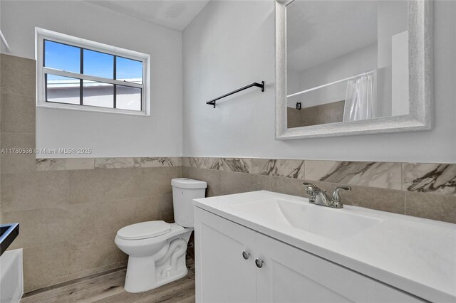 7320 Biltmore Blvd, Miramar, FL 33023 - bathroom featuring tile walls, wood finished floors, toilet, vanity, and a shower with curtain