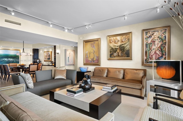 living area featuring track lighting and visible vents