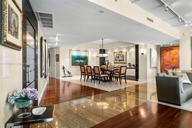 dining room with baseboards, rail lighting, and visible vents