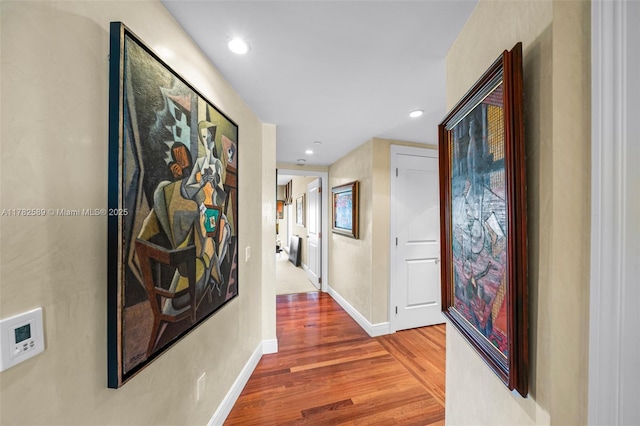 hall featuring wood finished floors, baseboards, and recessed lighting