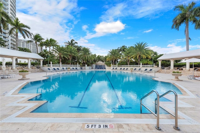community pool with fence and a patio