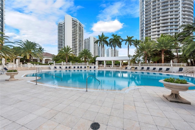 community pool featuring fence and a patio