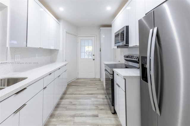 6440 SW 20th St, Miramar, FL 33023 - kitchen featuring appliances with stainless steel finishes, modern cabinets, light wood-style flooring, white cabinets, and recessed lighting