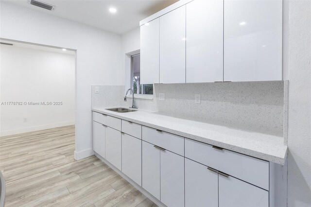 6440 SW 20th St, Miramar, FL 33023 - kitchen with a sink, white cabinetry, light wood-style flooring, light stone countertops, and modern cabinets