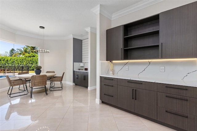 10972 Pine Lodge Trl, Davie, FL 33328 - kitchen with crown molding, pendant lighting, light stone countertops, dark brown cabinetry, and baseboards