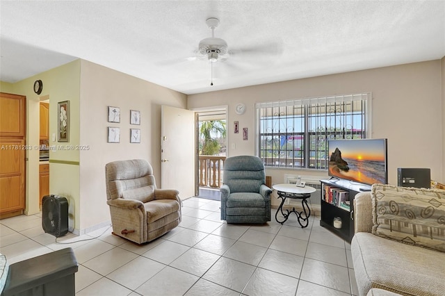 living area with light tile patterned floors, a textured ceiling, and ceiling fan