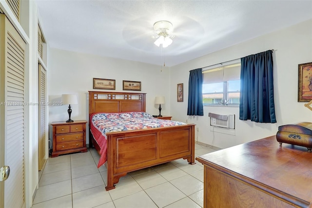 bedroom featuring light tile patterned floors, ceiling fan, and a wall unit AC