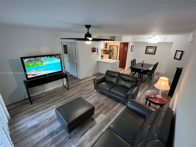 living area featuring wood finished floors, ceiling fan, and baseboards