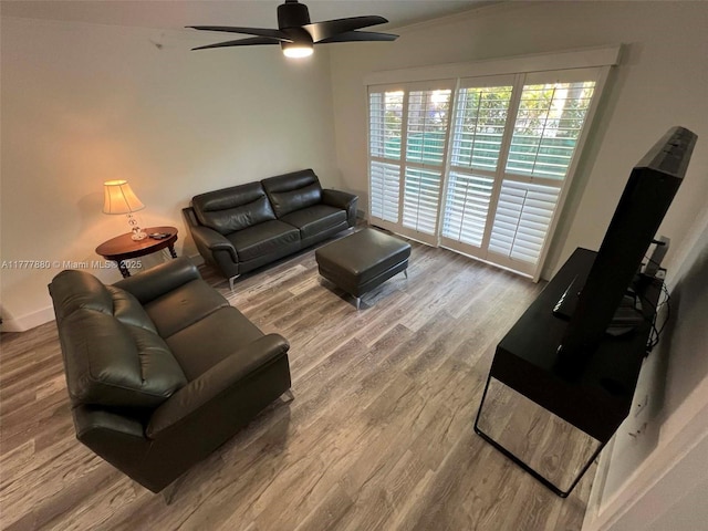 living area with ceiling fan, baseboards, and wood finished floors