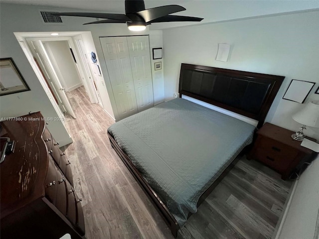 bedroom featuring visible vents, a closet, a ceiling fan, and wood finished floors