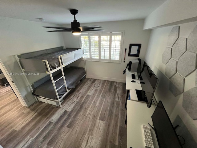 interior space with ceiling fan, baseboards, and wood finished floors