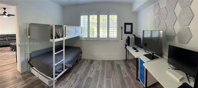 bedroom featuring baseboards and wood finished floors