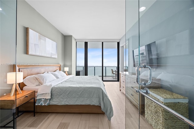 bedroom featuring floor to ceiling windows, light wood-type flooring, and access to exterior