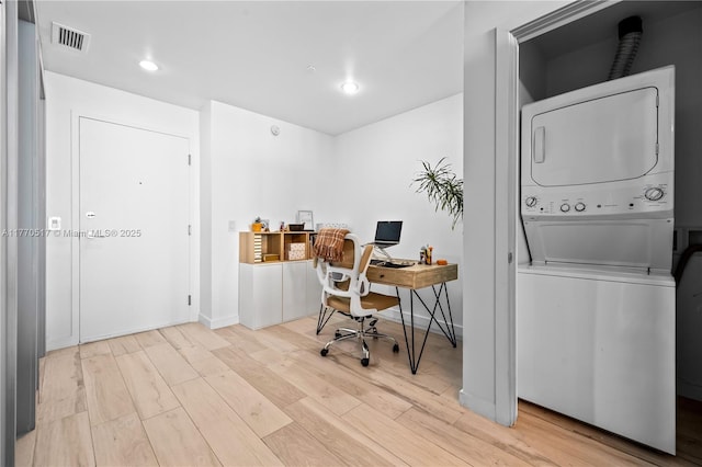 office featuring baseboards, visible vents, stacked washer / dryer, recessed lighting, and wood finished floors