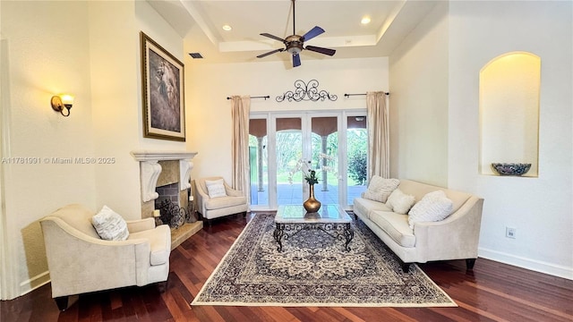 sitting room with a high end fireplace, baseboards, a ceiling fan, and wood finished floors