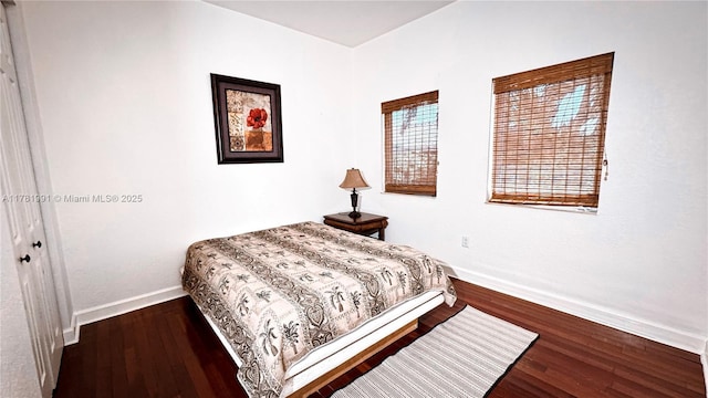 bedroom with baseboards and wood finished floors