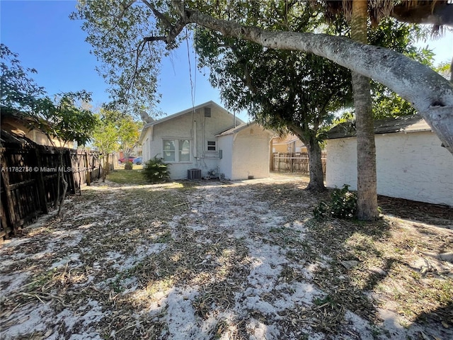 exterior space with stucco siding, a fenced backyard, and central AC unit