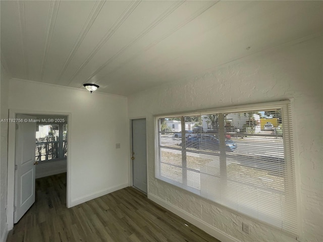 unfurnished dining area with wood finished floors, crown molding, and baseboards