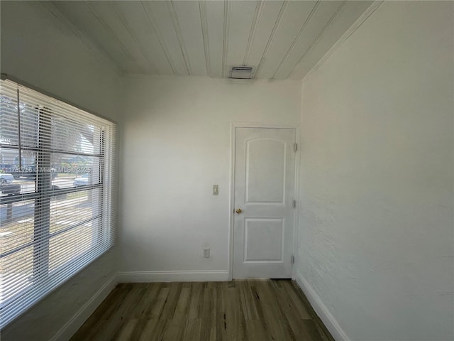 interior space featuring crown molding, wood finished floors, wood ceiling, baseboards, and visible vents