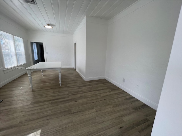 spare room with dark wood finished floors, baseboards, and wooden ceiling
