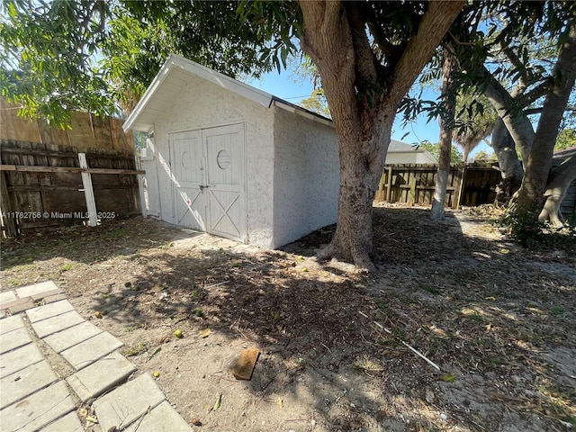 view of shed featuring fence