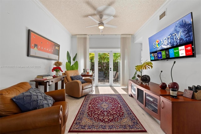 living area featuring crown molding, visible vents, ceiling fan, and a textured ceiling