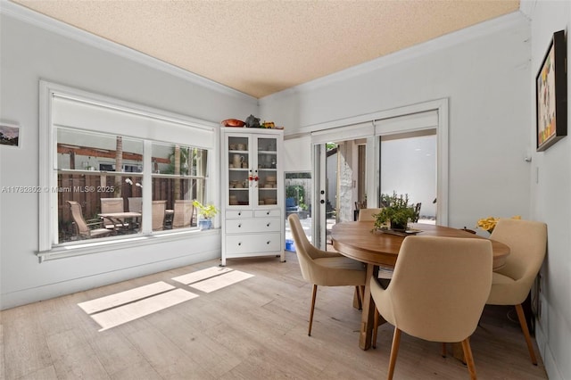 dining space with light wood finished floors, french doors, a textured ceiling, and crown molding