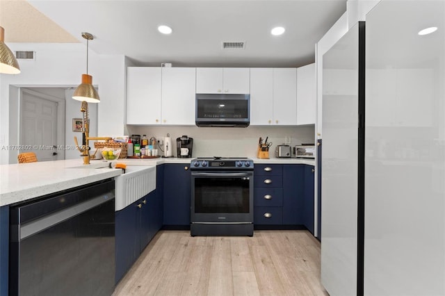 kitchen featuring light wood-style floors, dishwashing machine, stainless steel microwave, range, and blue cabinets