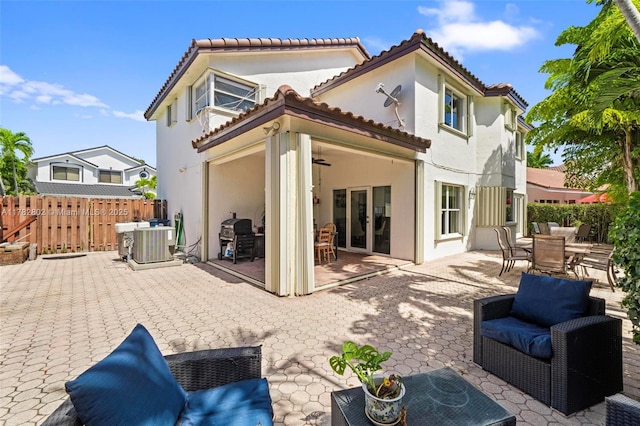 back of property featuring outdoor dining area, stucco siding, fence, french doors, and central AC unit