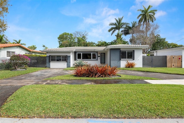 ranch-style house featuring stucco siding, a front yard, aphalt driveway, and fence