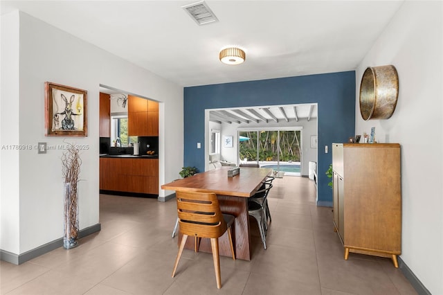 dining room featuring plenty of natural light, visible vents, and baseboards