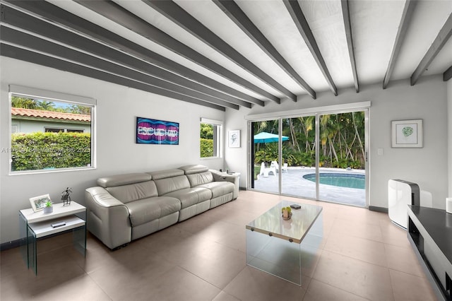 living area featuring beamed ceiling, tile patterned floors, and baseboards