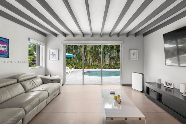 tiled living area featuring beam ceiling